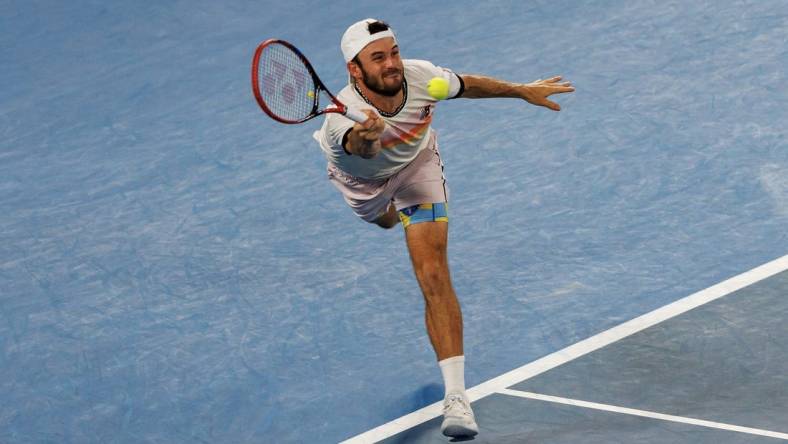 Jan 27, 2023; Melbourne, Victoria, Australia; Tommy Paul of the United States hits a shot against Novak Djokovic of Serbia on day twelve of the 2023 Australian Open tennis tournament at Melbourne Park. Mandatory Credit: Mike Frey-USA TODAY Sports