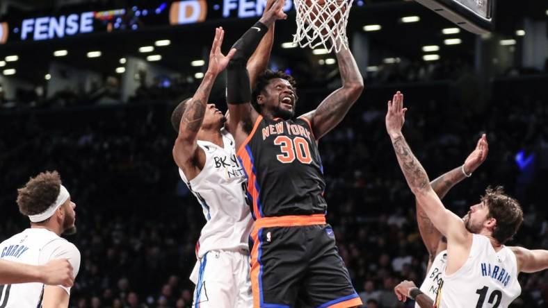 Jan 28, 2023; Brooklyn, New York, USA;  New York Knicks forward Julius Randle (30) drives past Brooklyn Nets center Nic Claxton (33) for a layup attempt in the second quarter at Barclays Center. Mandatory Credit: Wendell Cruz-USA TODAY Sports