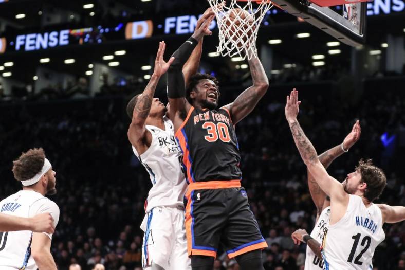 Jan 28, 2023; Brooklyn, New York, USA;  New York Knicks forward Julius Randle (30) drives past Brooklyn Nets center Nic Claxton (33) for a layup attempt in the second quarter at Barclays Center. Mandatory Credit: Wendell Cruz-USA TODAY Sports