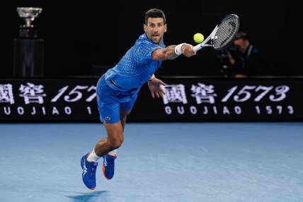 Jan 29, 2023; Melbourne, Victoria, Australia; Novak Djokovic of Serbia hits a shot against Stefanos Tsitsipas of Greece at the men's final on day fourteen of the 2023 Australian Open tennis tournament at Melbourne Park. Mandatory Credit: Mike Frey-USA TODAY Sports