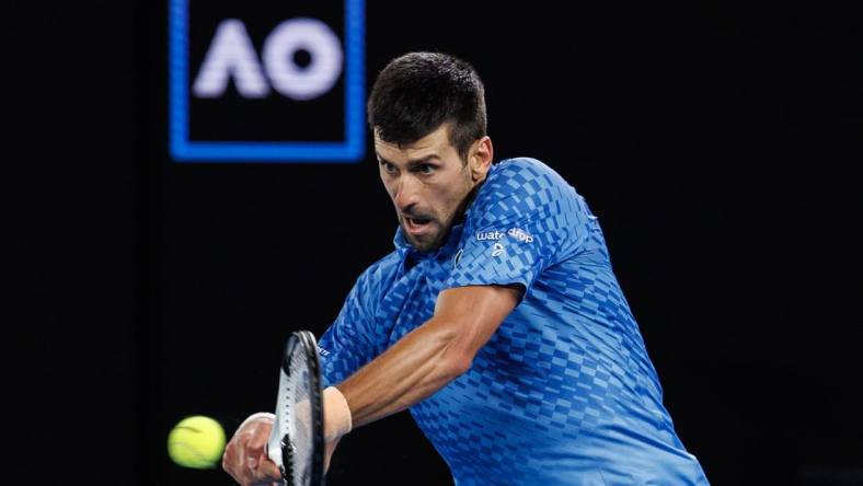 Jan 29, 2023; Melbourne, Victoria, Australia; Novak Djokovic of Serbia hits a shot against Stefanos Tsitsipas of Greece at the men's final on day fourteen of the 2023 Australian Open tennis tournament at Melbourne Park. Mandatory Credit: Mike Frey-USA TODAY Sports