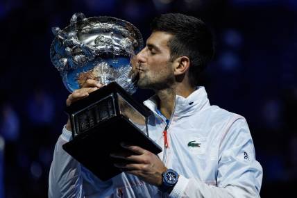 Jan 29, 2023; Melbourne, Victoria, Australia; Novak Djokovic of Serbia poses with the trophy after beating  Stefanos Tsitsipas of Greece in the men's final on day fourteen of the 2023 Australian Open tennis tournament at Melbourne Park. Mandatory Credit: Mike Frey-USA TODAY Sports