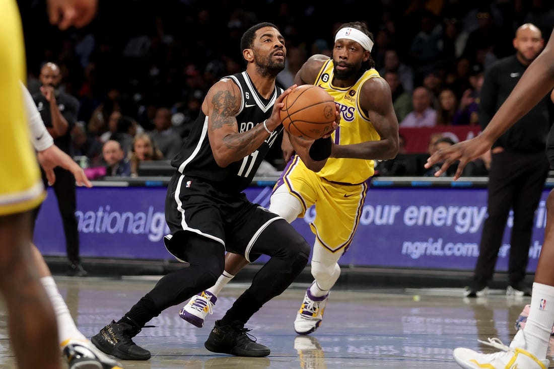 Jan 30, 2023; Brooklyn, New York, USA; Brooklyn Nets guard Kyrie Irving (11) takes a shot against Los Angeles Lakers guard Patrick Beverley (21) during the first quarter at Barclays Center. Mandatory Credit: Brad Penner-USA TODAY Sports