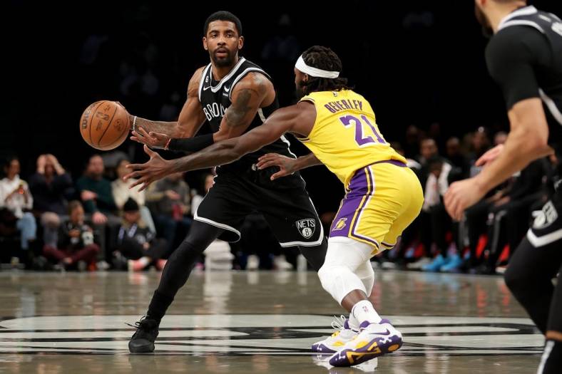 Jan 30, 2023; Brooklyn, New York, USA; Brooklyn Nets guard Kyrie Irving (11) passes the ball against Los Angeles Lakers guard Patrick Beverley (21) during the first quarter at Barclays Center. Mandatory Credit: Brad Penner-USA TODAY Sports