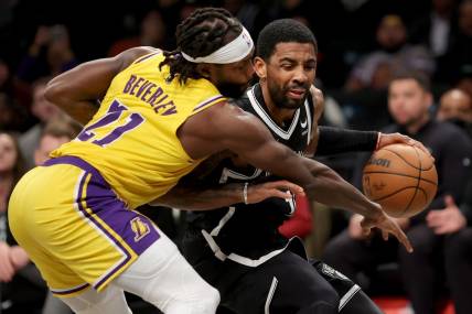 Jan 30, 2023; Brooklyn, New York, USA; Brooklyn Nets guard Kyrie Irving (11) is fouled as he brings the ball up court by Los Angeles Lakers guard Patrick Beverley (21) during the second quarter at Barclays Center. Mandatory Credit: Brad Penner-USA TODAY Sports