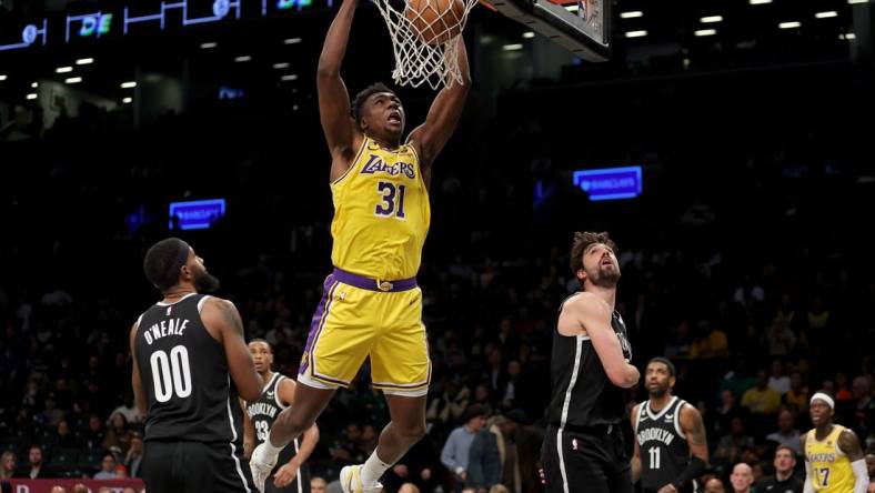 Jan 30, 2023; Brooklyn, New York, USA; Los Angeles Lakers center Thomas Bryant (31) dunks against Brooklyn Nets forwards Royce O'Neale (00) and Joe Harris (12) during the third quarter at Barclays Center. Mandatory Credit: Brad Penner-USA TODAY Sports