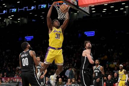 Jan 30, 2023; Brooklyn, New York, USA; Los Angeles Lakers center Thomas Bryant (31) dunks against Brooklyn Nets forwards Royce O'Neale (00) and Joe Harris (12) during the third quarter at Barclays Center. Mandatory Credit: Brad Penner-USA TODAY Sports