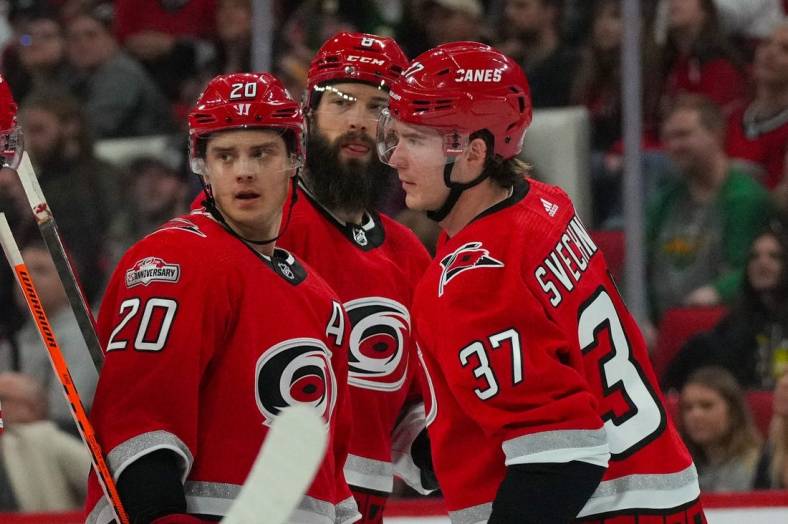 Jan 19, 2023; Raleigh, North Carolina, USA;  Carolina Hurricanes center Sebastian Aho (20) right wing Andrei Svechnikov (37) and defenseman Brent Burns (8) look on against the Minnesota Wild during the first period at PNC Arena. Mandatory Credit: James Guillory-USA TODAY Sports