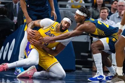 Feb 2, 2023; Indianapolis, Indiana, USA; Los Angeles Lakers forward Anthony Davis (3) grabs a loose the ball while Indiana Pacers guard Buddy Hield (24) defends in the first quarter at Gainbridge Fieldhouse. Mandatory Credit: Trevor Ruszkowski-USA TODAY Sports