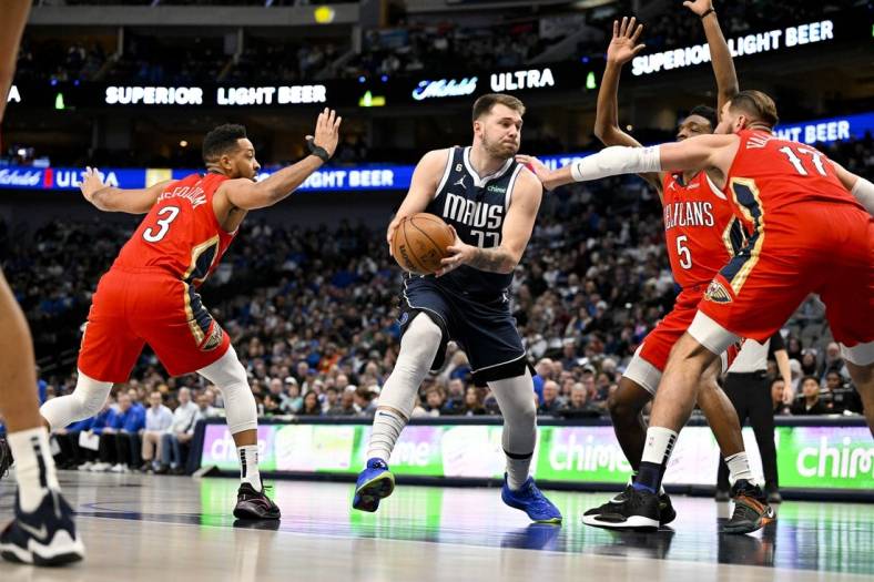 Feb 2, 2023; Dallas, Texas, USA; Dallas Mavericks guard Luka Doncic (77) drives to the basket past New Orleans Pelicans guard CJ McCollum (3) and forward Herbert Jones (5) and center Jonas Valanciunas (17) during the first quarter at the American Airlines Center. Mandatory Credit: Jerome Miron-USA TODAY Sports