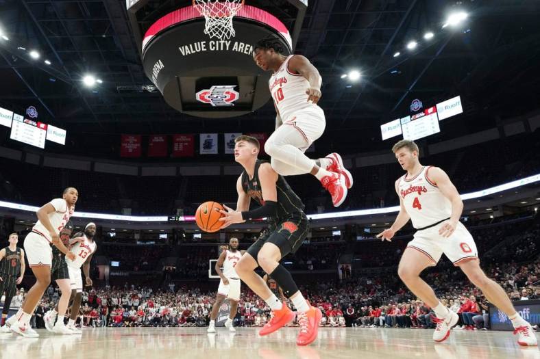 Feb 2, 2023; Columbus, OH, USA;  Ohio State Buckeyes forward Brice Sensabaugh (10) leaps over Wisconsin Badgers guard Connor Essegian (3) during the first half of the NCAA men   s basketball game at Value City Arena. Ohio State lost 65-60. Mandatory Credit: Adam Cairns-The Columbus Dispatch

Basketball Ceb Mbk Wisconsin Wisconsin At Ohio State