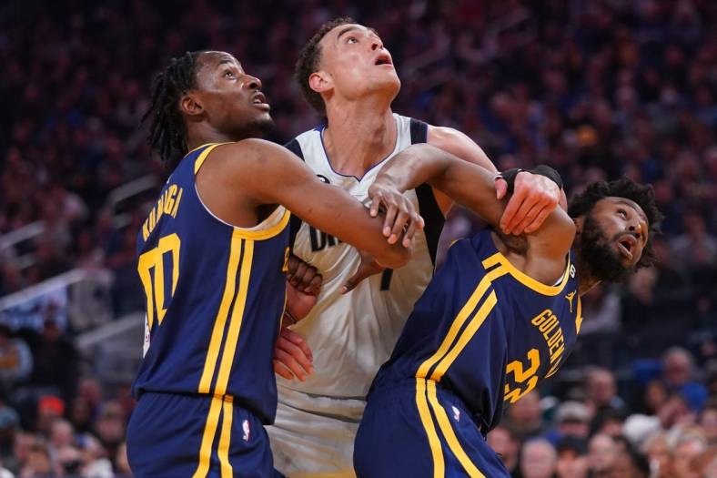 Feb 4, 2023; San Francisco, California, USA; Dallas Mavericks center Dwight Powell (7) battles for position against Golden State Warriors forward Jonathan Kuminga (00) and forward Andrew Wiggins (22) in the second quarter at the Chase Center. Mandatory Credit: Cary Edmondson-USA TODAY Sports