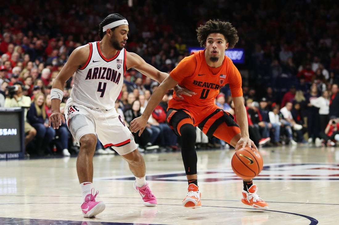 Feb 4, 2023; Tucson, Arizona, USA; Oregon State Beavers guard Jordan Pope (0) drives to the net against Arizona Wildcats guard Kylan Boswell (4) in the first half at McKale Center. Mandatory Credit: Zachary BonDurant-USA TODAY Sports