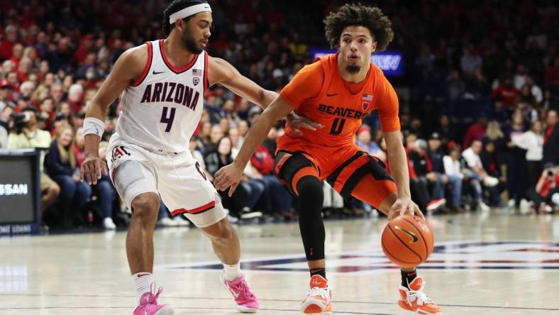 Feb 4, 2023; Tucson, Arizona, USA; Oregon State Beavers guard Jordan Pope (0) drives to the net against Arizona Wildcats guard Kylan Boswell (4) in the first half at McKale Center. Mandatory Credit: Zachary BonDurant-USA TODAY Sports