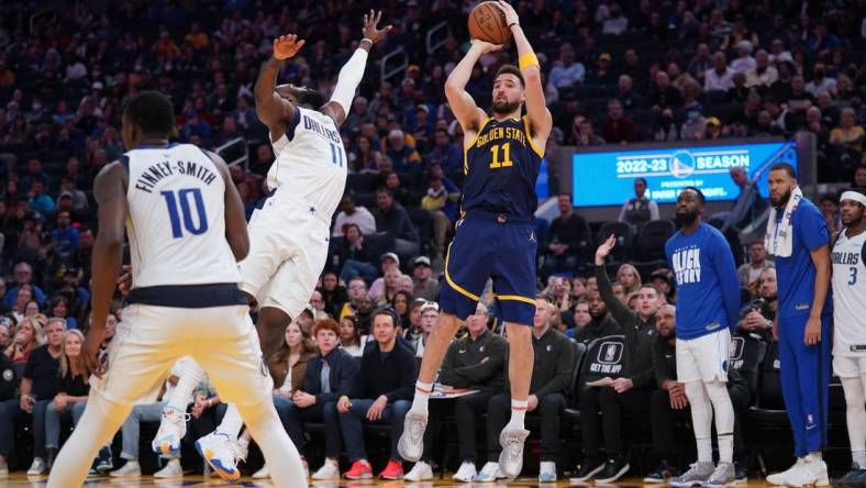 Feb 4, 2023; San Francisco, California, USA; Golden State Warriors guard Klay Thompson (11) shoots the ball over Dallas Mavericks forward Tim Hardaway Jr. (11) in the fourth quarter at the Chase Center. Mandatory Credit: Cary Edmondson-USA TODAY Sports