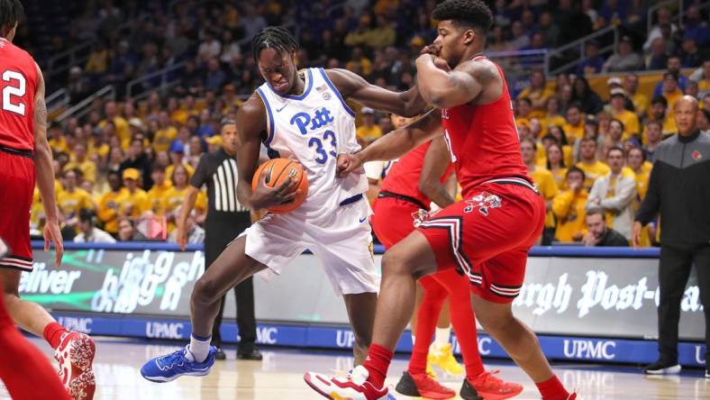 Pittsburgh Panthers Federiko Federiko (33) gets fouled by Louisville Cardinals Sydney Curry (21) while driving to the basket during the first half on February 7, 2023 at the Petersen Events Center in Pittsburgh, PA.

Pittsburgh Panthers Vs Louisville Mens Basketball