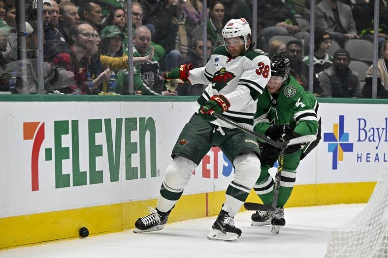 Feb 8, 2023; Dallas, Texas, USA; Minnesota Wild right wing Ryan Hartman (38) and Dallas Stars defenseman Miro Heiskanen (4) chase the puck in the Wild zone during the first period at the American Airlines Center. Mandatory Credit: Jerome Miron-USA TODAY Sports