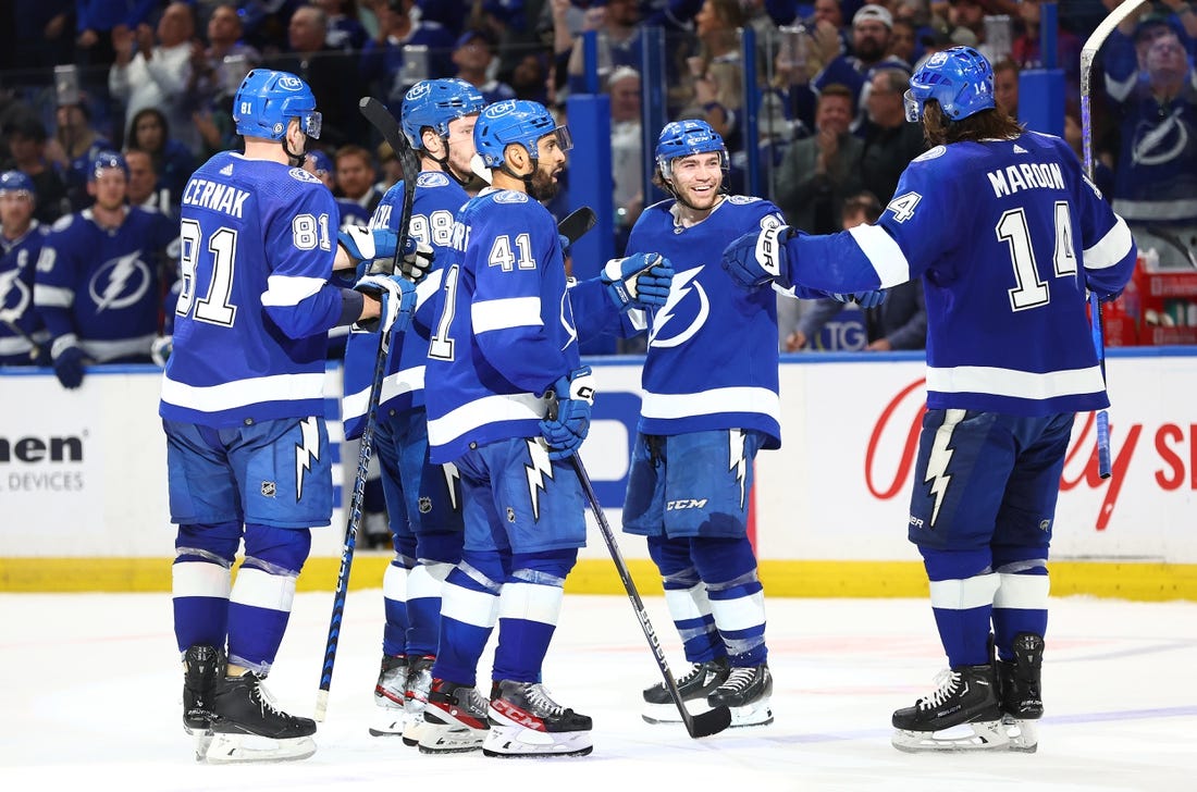 Feb 9, 2023; Tampa, Florida, USA; Tampa Bay Lightning defenseman Mikhail Sergachev (98) is congratulated by Tampa Bay Lightning center Brayden Point (21) and teammates  after he scored during the third period at Amalie Arena. Mandatory Credit: Kim Klement-USA TODAY Sports