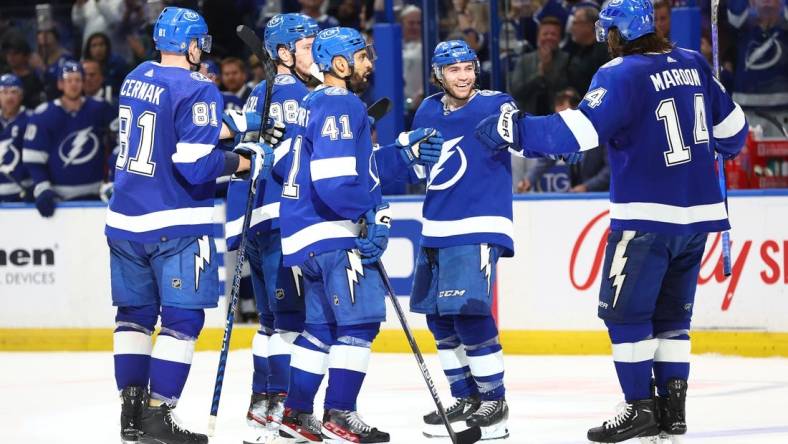 Feb 9, 2023; Tampa, Florida, USA; Tampa Bay Lightning defenseman Mikhail Sergachev (98) is congratulated by Tampa Bay Lightning center Brayden Point (21) and teammates  after he scored during the third period at Amalie Arena. Mandatory Credit: Kim Klement-USA TODAY Sports