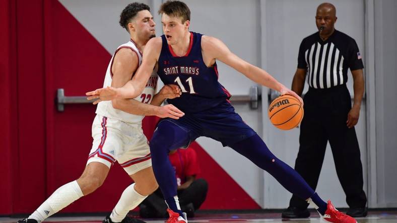 Feb 9, 2023; Los Angeles, California, USA; St. Mary's Gaels center Mitchell Saxen (11) moves the ball against Loyola Marymount Lions forward Alex Merkviladze (23) during the first half at Gersten Pavilion. Mandatory Credit: Gary A. Vasquez-USA TODAY Sports