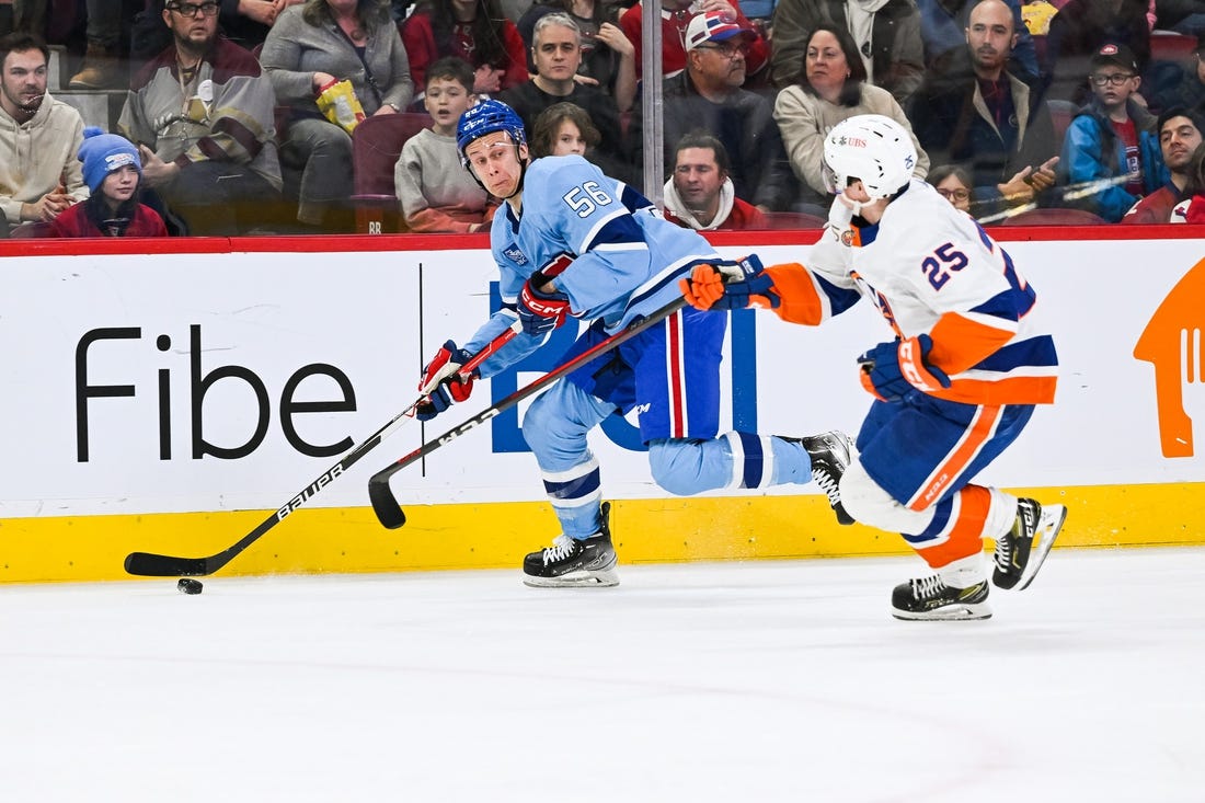 Feb 11, 2023; Montreal, Quebec, CAN; Montreal Canadiens right wing Jesse Ylonen (56) plays the puck against New York Islanders defenseman Sebastian Aho (25) during the second period at Bell Centre. Mandatory Credit: David Kirouac-USA TODAY Sports