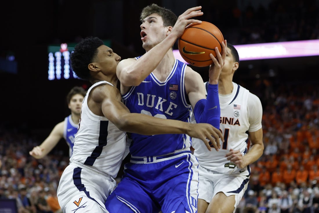 Feb 11, 2023; Charlottesville, Virginia, USA; Duke Blue Devils center Kyle Filipowski (30) drives to the basket as Virginia Cavaliers guard Ryan Dunn (13) defends in the first half at John Paul Jones Arena. Mandatory Credit: Geoff Burke-USA TODAY Sports