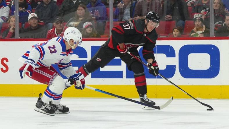 Feb 11, 2023; Raleigh, North Carolina, USA;  Carolina Hurricanes right wing Andrei Svechnikov (37) gets ready to take a shot past New York Rangers defenseman Adam Fox (23) during the first period at PNC Arena. Mandatory Credit: James Guillory-USA TODAY Sports