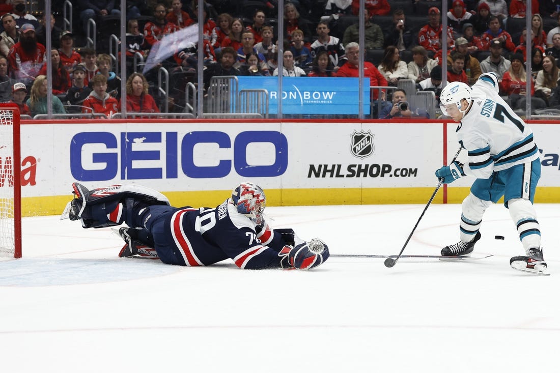 Feb 12, 2023; Washington, District of Columbia, USA; Washington Capitals goaltender Charlie Lindgren (79) dives to poke the puck from San Jose Sharks center Nico Sturm (7) on a breakaway in the second period at Capital One Arena. Mandatory Credit: Geoff Burke-USA TODAY Sports