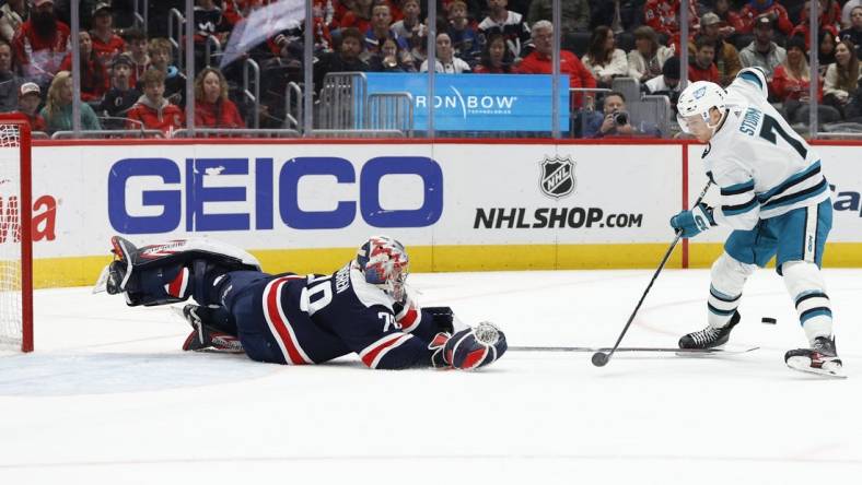 Feb 12, 2023; Washington, District of Columbia, USA; Washington Capitals goaltender Charlie Lindgren (79) dives to poke the puck from San Jose Sharks center Nico Sturm (7) on a breakaway in the second period at Capital One Arena. Mandatory Credit: Geoff Burke-USA TODAY Sports