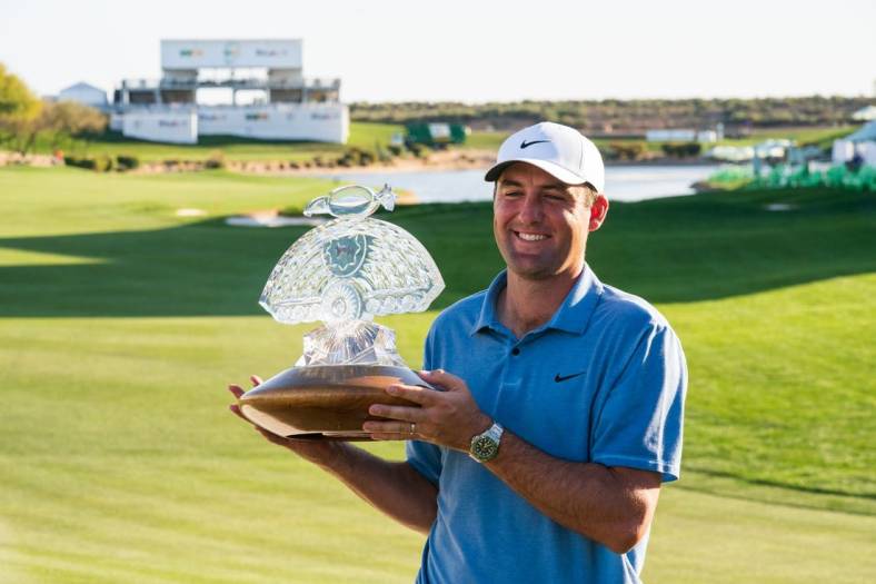 Feb 12, 2023; Scottsdale, Arizona,USA; Scotty Scheffler celebrates with the championship trophy after his victory during the final round of the WM Phoenix Open golf tournament. Mandatory Credit: Allan Henry-USA TODAY Sports