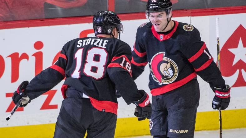 Feb 13, 2023; Ottawa, Ontario, CAN; Ottawa Senators left wing Tim Stutzle celebrates a goal scored by right wing Alex DeBrincat (12) in the third period against the Calgary Flames at the Canadian Tire Centre. Mandatory Credit: Marc DesRosiers-USA TODAY Sports