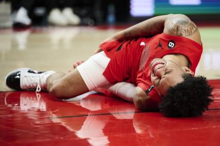 Feb 14, 2023; Portland, Oregon, USA; Portland Trail Blazers guard Anfernee Simons (1) grimaces in pain after injuring himself during the second half against the Washington Wizards at Moda Center. Mandatory Credit: Troy Wayrynen-USA TODAY Sports