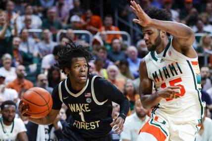 Feb 18, 2023; Coral Gables, Florida, USA; Wake Forest Demon Deacons guard Tyree Appleby (1) drives to the basket against Miami Hurricanes forward Norchad Omier (15) during the first half at Watsco Center. Mandatory Credit: Sam Navarro-USA TODAY Sports