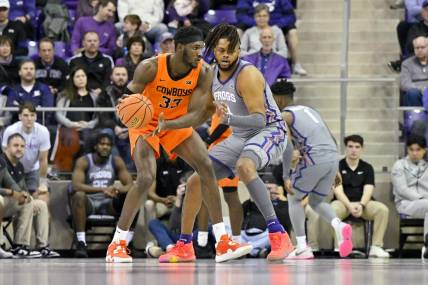 Feb 18, 2023; Fort Worth, Texas, USA; Oklahoma State Cowboys forward Moussa Cisse (33) looks to move the ball past TCU Horned Frogs center Eddie Lampkin Jr. (4) during the first half at the Ed and Rae Schollmaier Arena. Mandatory Credit: Jerome Miron-USA TODAY Sports