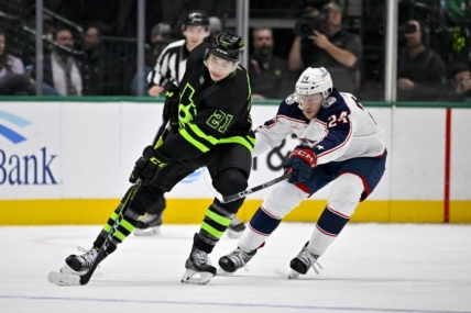 Feb 18, 2023; Dallas, Texas, USA; Dallas Stars left wing Jason Robertson (21) keeps the puck away from Columbus Blue Jackets right wing Mathieu Olivier (24) during the first period at the American Airlines Center. Mandatory Credit: Jerome Miron-USA TODAY Sports