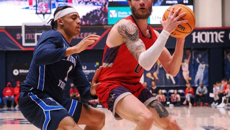 Feb 18, 2023; Moraga, California, USA; St. Mary's Gaels guard Logan Johnson (0) controls the ball against BYU Cougars guard Trey Stewart (1) during the first half at University Credit Union Pavilion. Mandatory Credit: Kelley L Cox-USA TODAY Sports