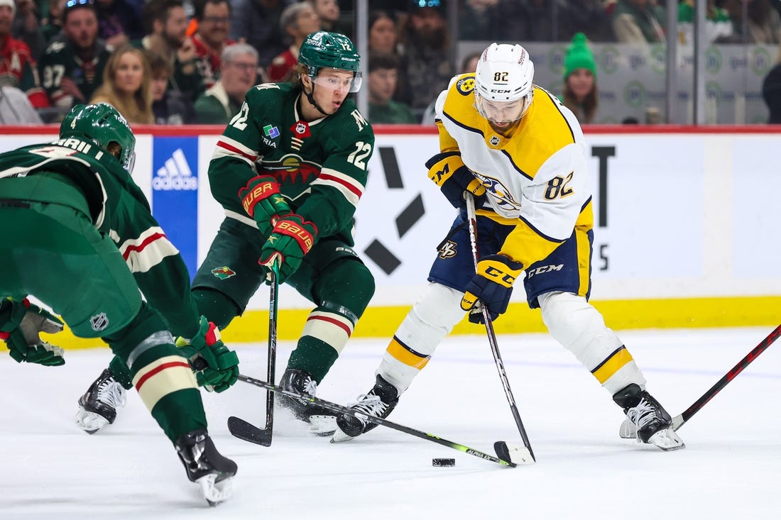 Feb 19, 2023; Saint Paul, Minnesota, USA; Nashville Predators center Tommy Novak (82) skates with the puck while Minnesota Wild left wing Matt Boldy (12) defends during the first period at Xcel Energy Center. Mandatory Credit: Matt Krohn-USA TODAY Sports