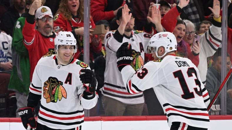 Feb 19, 2023; Chicago, Illinois, USA;  Chicago Blackhawks forward Patrick Kane (88) celebrates with forward Max Domi (13) after scoring his third goal of the game in the second period against the Toronto Maple Leafs at United Center. Mandatory Credit: Jamie Sabau-USA TODAY Sports