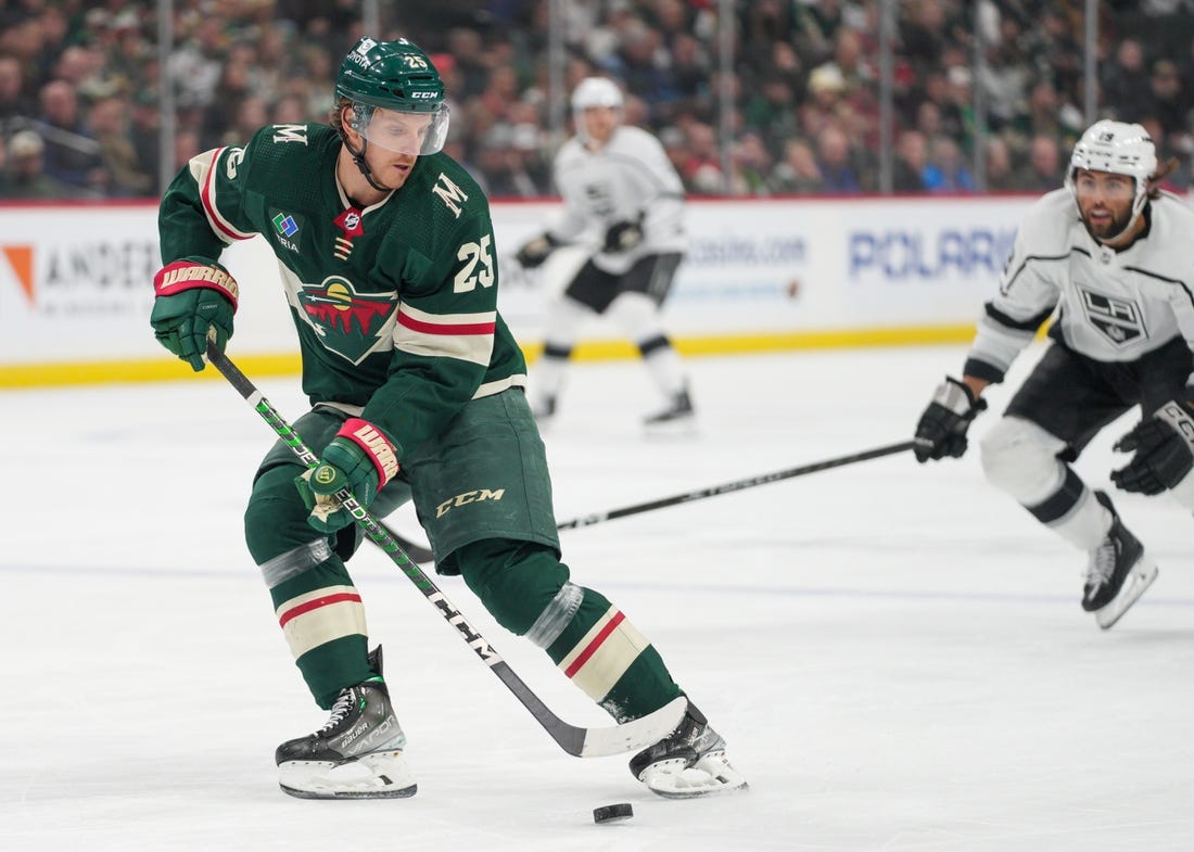 Feb 21, 2023; Saint Paul, Minnesota, USA; Minnesota Wild defenseman Jonas Brodin (25) retrieves the puck defended by Los Angeles Kings left wing Alex Iafallo (19) in the first period at Xcel Energy Center. Mandatory Credit: Matt Blewett-USA TODAY Sports