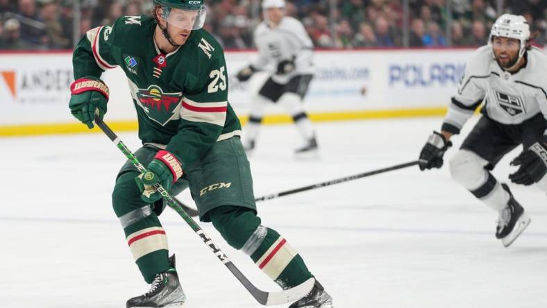 Feb 21, 2023; Saint Paul, Minnesota, USA; Minnesota Wild defenseman Jonas Brodin (25) retrieves the puck defended by Los Angeles Kings left wing Alex Iafallo (19) in the first period at Xcel Energy Center. Mandatory Credit: Matt Blewett-USA TODAY Sports