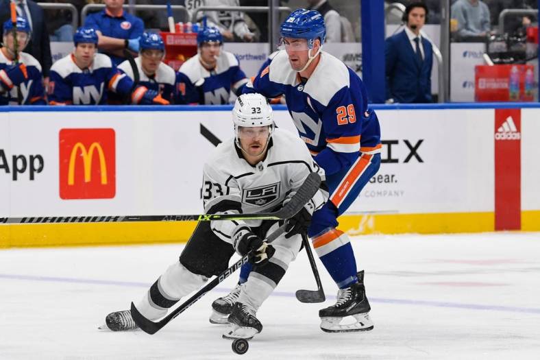 Feb 24, 2023; Elmont, New York, USA;  Los Angeles Kings right wing Viktor Arvidsson (33) skates with the puck defended by New York Islanders center Brock Nelson (29) during the first period at UBS Arena. Mandatory Credit: Dennis Schneidler-USA TODAY Sports