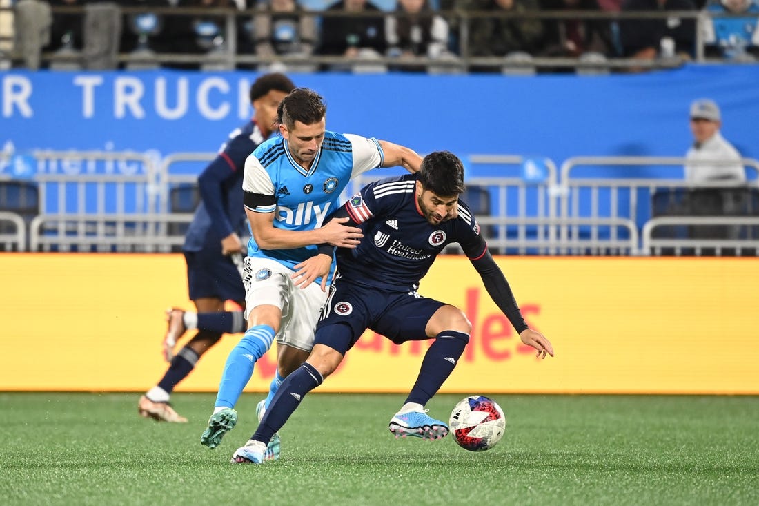 Feb 25, 2023; Charlotte, North Carolina, USA; Charlotte FC midfielder Brandt Bronico (13) and New England Revolution midfielder Carles Gil (10) fight for the ball in the first half at Bank of America Stadium. Mandatory Credit: Bob Donnan-USA TODAY Sports