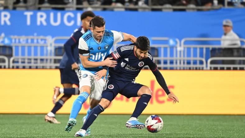 Feb 25, 2023; Charlotte, North Carolina, USA; Charlotte FC midfielder Brandt Bronico (13) and New England Revolution midfielder Carles Gil (10) fight for the ball in the first half at Bank of America Stadium. Mandatory Credit: Bob Donnan-USA TODAY Sports