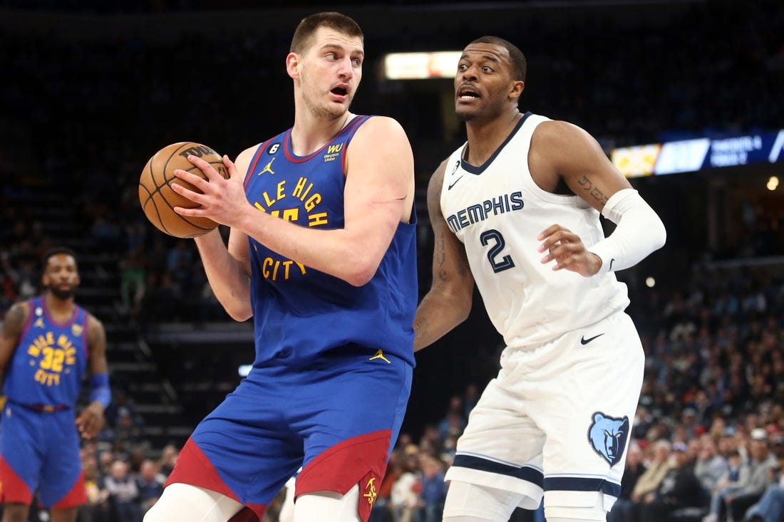 Feb 25, 2023; Memphis, Tennessee, USA; Denver Nuggets center Nikola Jokic (15) spins toward the basket as Memphis Grizzlies forward Xavier Tillman (2) defends during the first half at FedExForum. Mandatory Credit: Petre Thomas-USA TODAY Sports