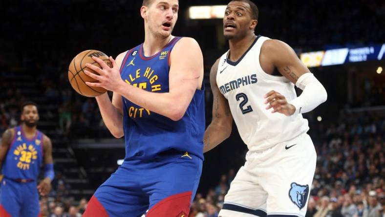 Feb 25, 2023; Memphis, Tennessee, USA; Denver Nuggets center Nikola Jokic (15) spins toward the basket as Memphis Grizzlies forward Xavier Tillman (2) defends during the first half at FedExForum. Mandatory Credit: Petre Thomas-USA TODAY Sports