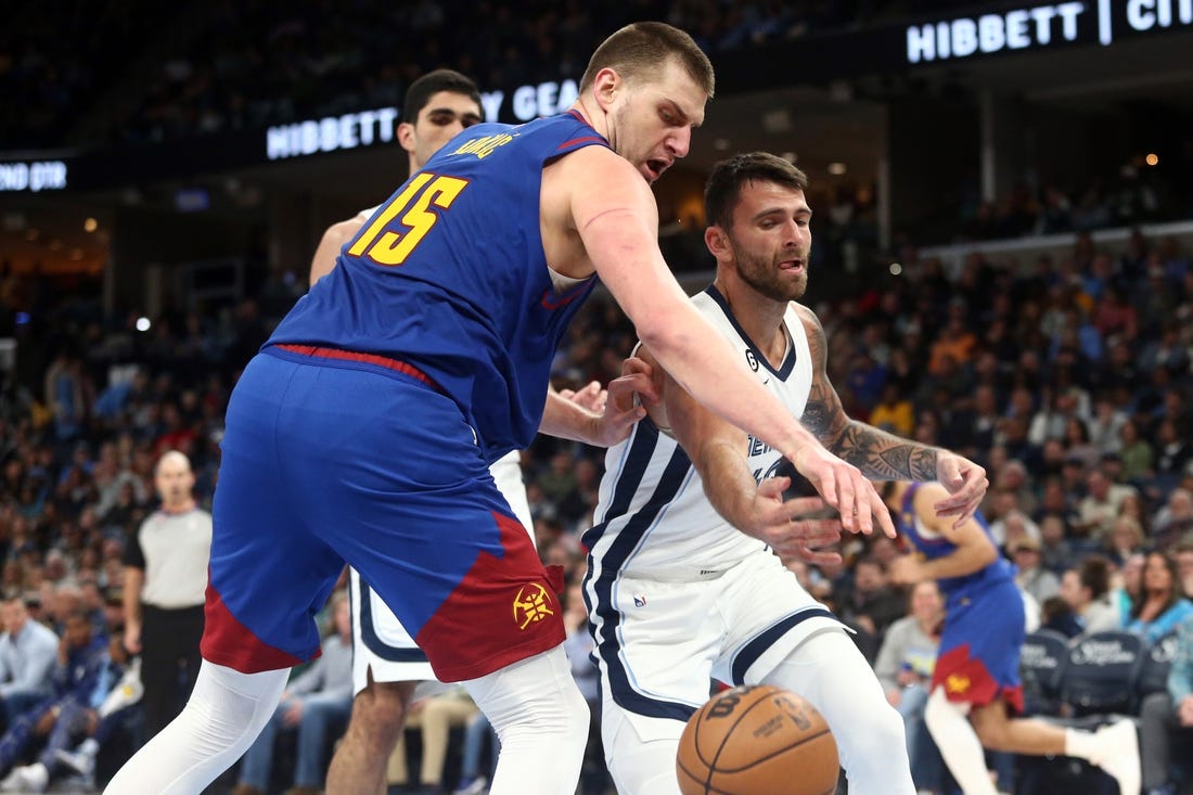 Feb 25, 2023; Memphis, Tennessee, USA; Denver Nuggets center Nikola Jokic (15) and Memphis Grizzlies guard John Konchar (46) battle for a loose ball during the first half at FedExForum. Mandatory Credit: Petre Thomas-USA TODAY Sports