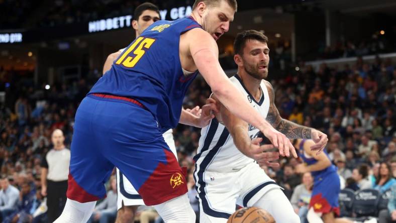 Feb 25, 2023; Memphis, Tennessee, USA; Denver Nuggets center Nikola Jokic (15) and Memphis Grizzlies guard John Konchar (46) battle for a loose ball during the first half at FedExForum. Mandatory Credit: Petre Thomas-USA TODAY Sports