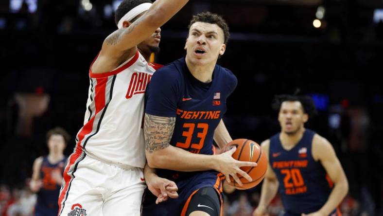Feb 26, 2023; Columbus, Ohio, USA; Illinois Fighting Illini forward Coleman Hawkins (33) drives in for the score as Ohio State Buckeyes guard Roddy Gayle Jr. (1) defends during the first half at Value City Arena. Mandatory Credit: Joseph Maiorana-USA TODAY Sports