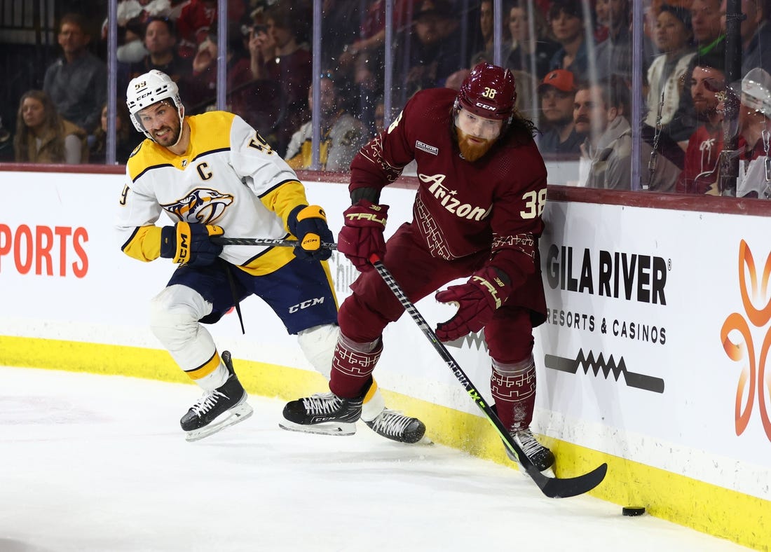 Feb 26, 2023; Tempe, Arizona, USA; Arizona Coyotes center Liam O'Brien (38) moves the puck against Nashville Predators defenseman Roman Josi (59) in the second period at Mullett Arena. Mandatory Credit: Mark J. Rebilas-USA TODAY Sports