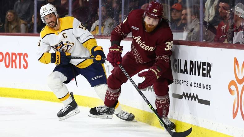 Feb 26, 2023; Tempe, Arizona, USA; Arizona Coyotes center Liam O'Brien (38) moves the puck against Nashville Predators defenseman Roman Josi (59) in the second period at Mullett Arena. Mandatory Credit: Mark J. Rebilas-USA TODAY Sports